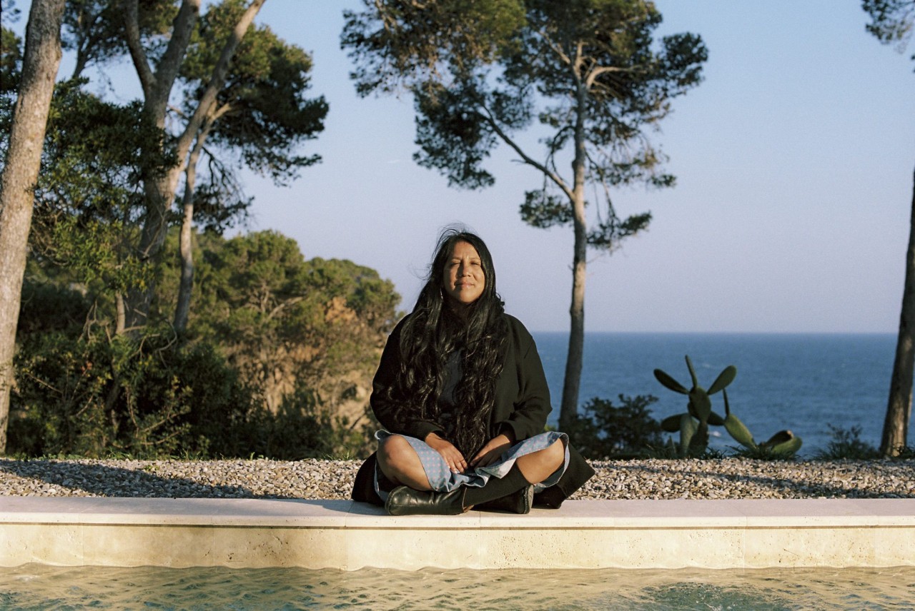 Die peruanische Schriftstellerin und Esayistin Gabriela Wiener sitzt am Strand.