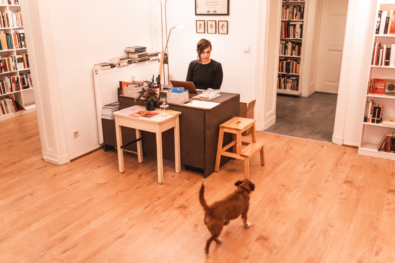 La librera Ana S. Pareja en su librería. Un perro pasea por el local.